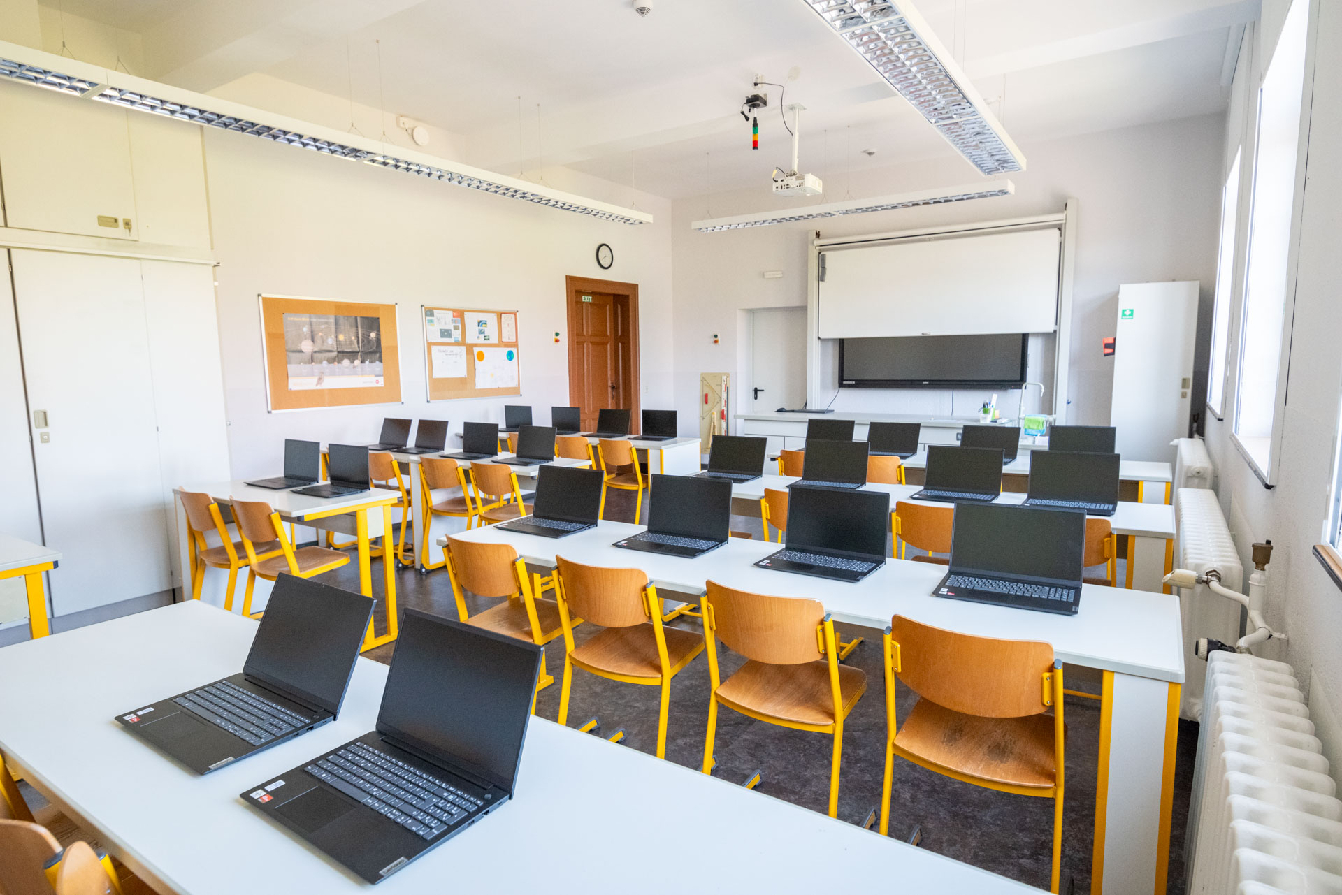 Raum mit Stühlen, Whiteboard und Laptops