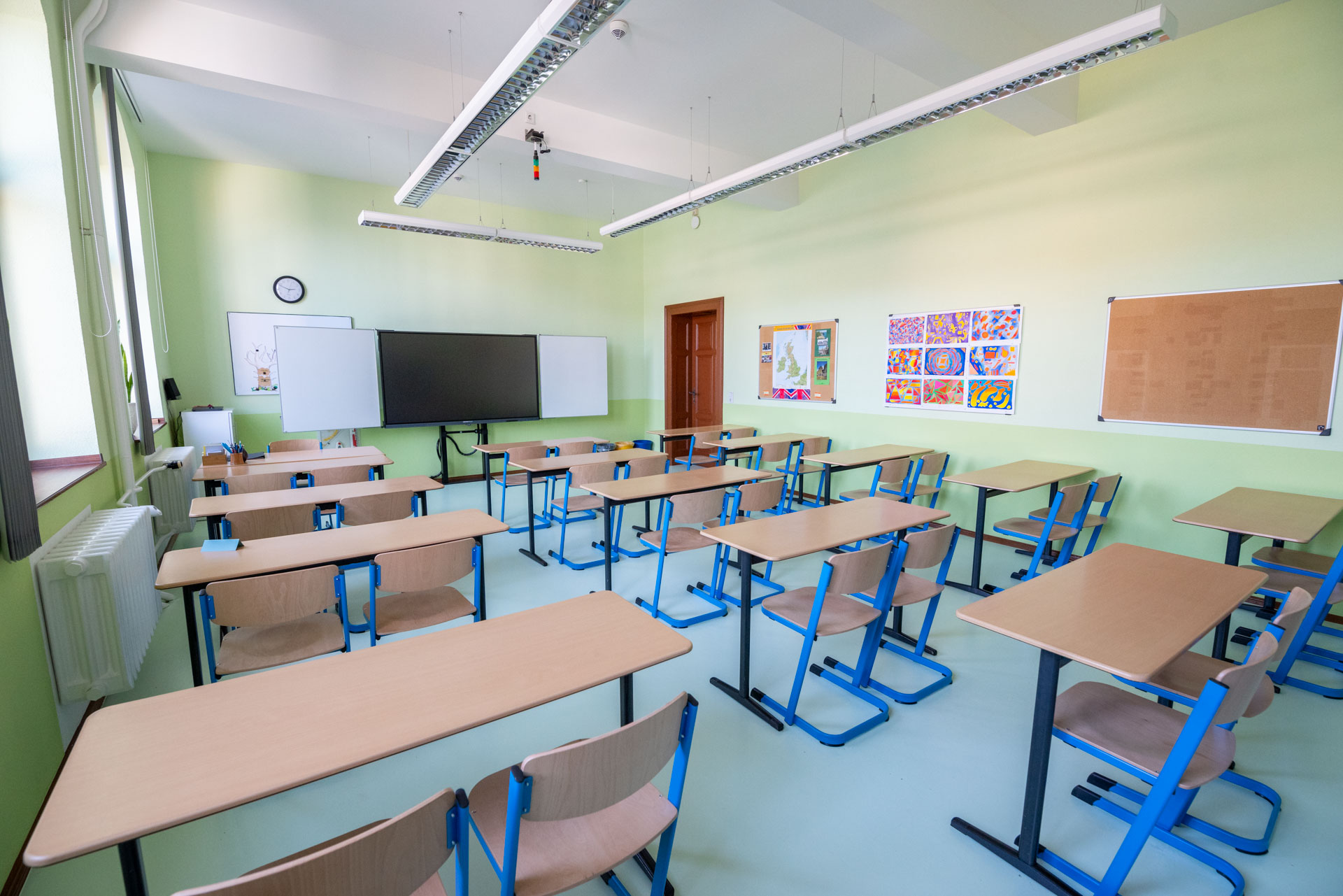 Ansicht eines Klassenzimmers mit digitaler Tafel und Tischen